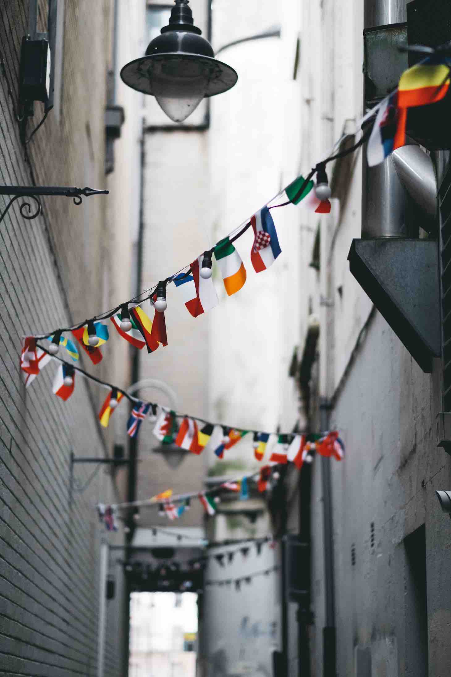 Drapeaux au-dessus ruelle. © Andrew Butler sur Unsplash.